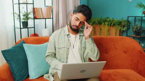 피곤한 프리랜서 노트북 편두통 아파트에서 스트레스로 남자는 노트북에서 일하고 메시지를 — 비디오