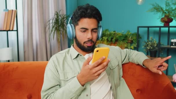 Glücklich Entspannter Überglücklicher Indischer Araber Mit Drahtlosen Kopfhörern Der Hause — Stockvideo