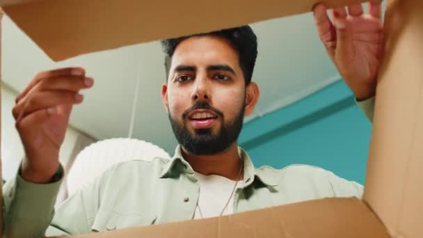 从盒子里面看 快乐的印度人在家里打开包裹 笑容满面的男购物者 网上商店的顾客打开纸板箱接受快速邮寄的购物礼物 — 图库视频影像