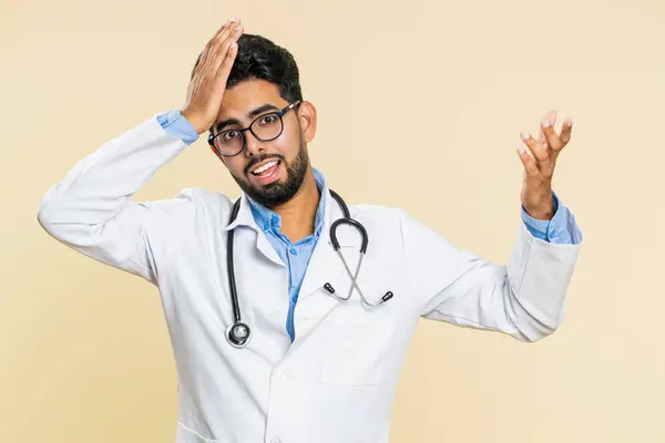 インドの若い医師の心臓病学者男性は絶望感と孤独感 神経衰弱 不運なニュース 失敗を感じています ベージュの背景に隔離されたアラビアの薬局の男 — ストック写真
