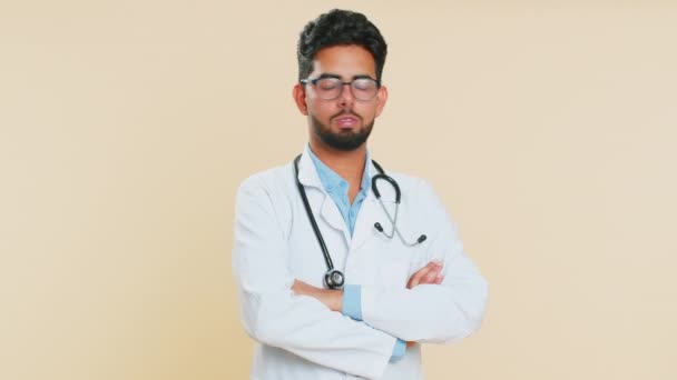 不快なインドの若い医師の心臓病学者の男性は不快な仕事 波の手 振るヘッドに不満を持って不快なひどい考えに反応し 悪い考えの提案を却下しません ベージュの背景にアラビアの男 — ストック動画