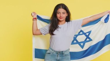 Hindistan 'dan gülümseyen genç bir kadın İsrail bayrağını tutuyor, savaşa karşı zafer işareti gösteriyor, başarı ve kazanma umuduyla, barış jesti yapıyor. Bağımsızlık, özgürlük, ulusal bayram Arap Hindu kız