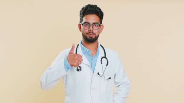 同じように インドの若い医師心臓専門家男性は同意し 肯定的な返信良いアイデアフィードバックを与え 成功の勝利を祝います ベージュの背景に隔離されたアラビアの薬局の男 — ストック動画