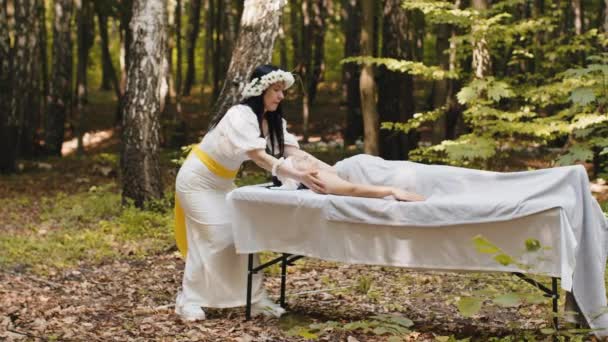 セラピストの女性医師が森の外で手でリラックスしたスパフェイスマッサージを作ります リラックスして休む 健康的なスキンケア 想像力 ファンタジー 物理化粧品セッション — ストック動画