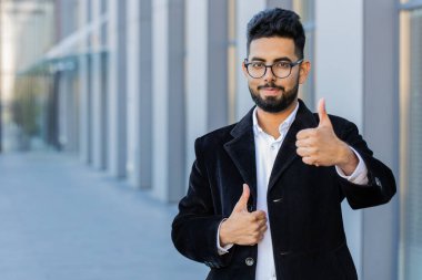 Gibi. Mutlu Hintli işadamı, olumlu yanıt veriyor. Tavsiye önerileri, reklamlar, iyi fikir geri bildirimleri, başarı zaferini kutluyor. Şehirdeki Arap Hindu serbest çalışan adam.