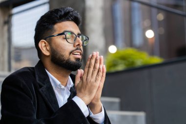 Hintli işadamı elini sıkarak şans diliyor Tanrı 'ya kapalı gözlerle dua ederek dışarıda af diliyor. Şehir merkezindeki Hindu serbest çalışan Arap bir adam. İş adamı yaşam tarzı