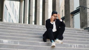 Mutsuz üzgün Hintli işadamı, şirketteki işsizlik sorunu çözme krizinden sonra kendini kötü hissederek strese girdi. Şehir merkezindeki merdivenlerde oturan Arap Hindu serbest çalışan adam.