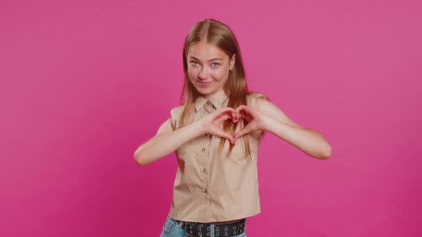 Влюблённая Женщина Улыбающаяся Привлекательная Женщина Делает Сердечный Жест Демонстрирует Знак — стоковое видео