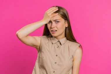 Avuç içi. Yazıklar olsun sana. Kafkas asıllı genç bir kadın surat hareketi yapıyor, sıkılmış, hayal kırıklığına uğramış, kötü haber, kederli. Mutsuz kız pembe stüdyo arka planında kapalı.