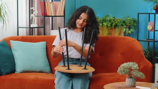 快乐的印度女人在家里组装家具 成功的桌子收集 搬进新公寓后的阿拉伯女孩 家具店的广告 抵押贷款 — 图库视频影像
