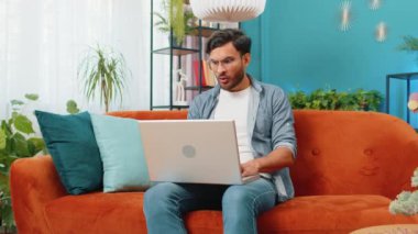 Hüzünlü Hintli adam dizüstü bilgisayar kullanıyor. İnternette arama yapıyor. Ani piyango kazasının kötü haber kaybı bilgisayar virüsüne yol açmasına şaşırıyor. Oturma odasındaki koltukta oturan Arap adam.