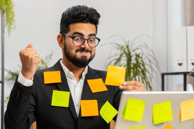 Ofiste dizüstü bilgisayarda çalışan yorgun Hintli işadamı üzerinde bir sürü çıkartma ile çalışıyor. Komik Arap meşguliyeti, can sıkıntısının çoklu görev gerektirdiğini hissediyor. Panik atak, son teslim tarihi
