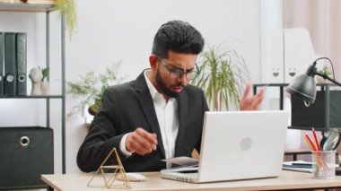 Laptop üzerinde çalışırken sinirli Hintli iş adamı, beklenmedik internet sitesi problemi, bilgisayar virüsü veri kaybı hackleme. Freelancer ofisteki kırık defter yüzünden kızgın.