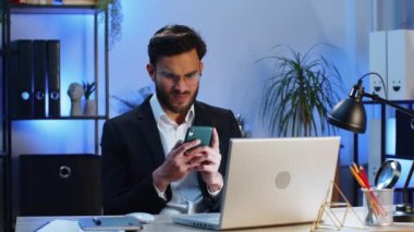 Hindistanlı işadamı akıllı telefon daktilo kullanıyor. Ani piyango sonuçlarını kaybediyor. Kötü haber, servet kaybı. Takım elbiseli erkek Hindu.