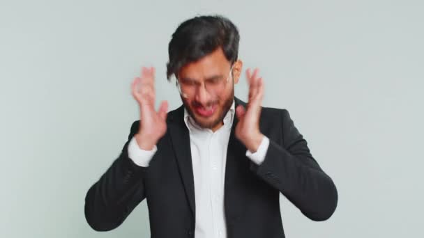 聞いたり聞いたりしたくない イライラしたイライラしたインドのビジネスマンは 不快な騒音の大きな声を無視するアドバイスを避け ジェスチャーなしで耳を覆う 灰色の背景にアラビアの男 — ストック動画