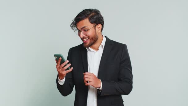 Szczęśliwy Podekscytowany Indyjski Biznesmen Facet Używać Smartfona Wpisując Przeszukiwanie Krzycząc — Wideo stockowe