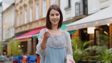 Neşeli, zengin, genç ve güzel bir kadın el hareketleriyle etrafa para saçıyor, daha fazla bahşiş, daha fazla kar, piyango kazanmak, paylaşmak, kutlamak. Kentsel şehir avrupa sokaklarında yürüyen bir kız