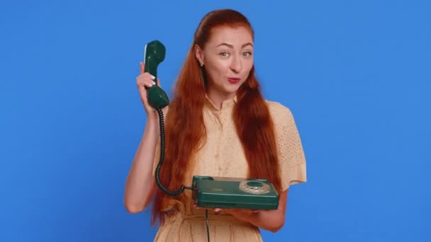 電話してくれ 80年代の有線ヴィンテージ電話で話している大人の女性は あなたが私を呼び戻す 会話の提案 ホットラインと言います 屋内ブルースタジオの背景に隔離された赤毛の少女 — ストック動画