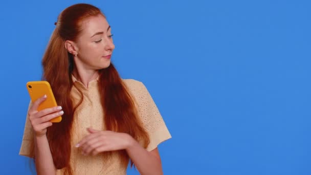 Genç Kızıl Saçlı Akıllı Telefon Kullanan Genç Bir Kız Internette — Stok video