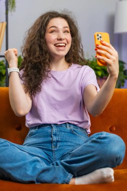 Mutlu genç bir kadın cep telefonu daktilosu kullanıyor ve 