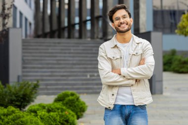 Mutlu Hintli bir adamın portresi güler yüzlü, kameraya bakan mutlu yüz hayal kuran, dinlenen rahatlayan, dışarıda iyi haberler veren. Şehir sokağındaki Arap adam. İş adamları. Kopyalama alanı