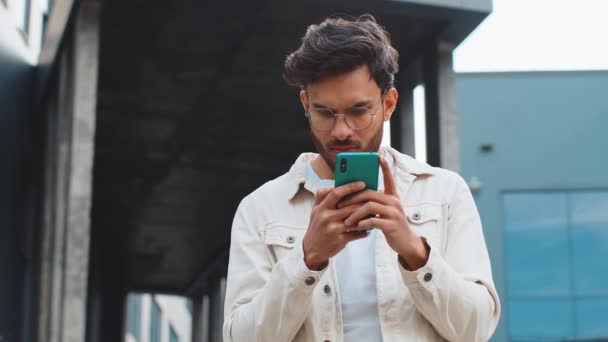 Förvånad Indisk Man Använder Smartphone Skriva Surfning Förlorar Blir Förvånad — Stockvideo