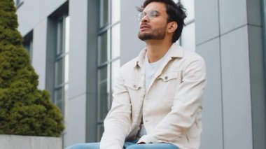 Dışarıdaki mali sorunlardan endişelenen yorgun, üzgün Hintli bir adam. Arap Hintli adam, şehir merkezindeki bankta oturan borç bütçe kaybını düşünürken hayal kırıklığına uğradı. Fazla çalışma