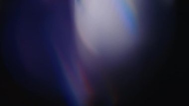 Çok renkli ışık siyah arkaplanda 4K görüntü sızdırıyor. Stüdyoda gaz sızıntısı var. Doğal aydınlatma ışınları bokeh etkisi. Çekimlerinizi birleştirmek, videoyu biçimlendirmek, geçişlerinizi