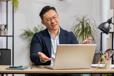 Dizüstü bilgisayarda çalışan Asyalı orta yaşlı iş adamı yazılım geliştirici kaybediyor kötü haberler karşısında şaşırıyor, merkez ofiste servet kaybı yaşanıyor. Son teslim tarihi, iflas. Serbest Çalışan Adam