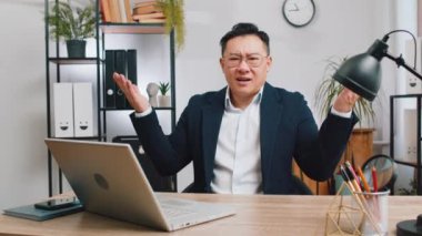 I dont know what to say. Confused business man working on laptop at office workplace. Freelancer feeling embarrassed about ambiguous question, having doubts, no answer idea, being clueless, uncertain
