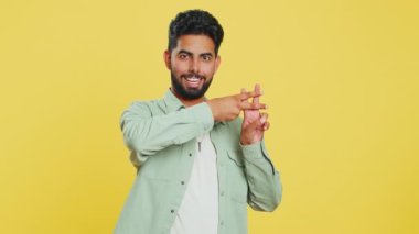 Etiket. Hintli adam parmaklarıyla çapraz sembol gösteriyor, işaretli mesajları seviyor, popüler sosyal medya içeriğini seviyor, internet eğilimlerini takip etmek için işaret veriyor. Sarı stüdyo geçmişi olan Arap bir genç.