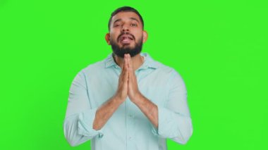 Lütfen, Tanrım yardım et. Hintli adam kameraya bakıp dilek diliyor, umutlu bir ifadeyle soruyor, özür diliyor, meditasyon yapıyor. Yeşil krom anahtar arka planında izole edilmiş bir Arap.
