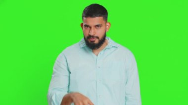 Gözüm üzerinde. Gözlerine ve kamerasına bakan özgüvenli adam, seni birini gözetlerken izlediğimi göster. Yeşil renkli anahtar arka planında izole edilmiş yakışıklı, hayal kırıklığına uğramış Hintli adam.