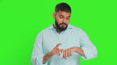 Ciddi şekilde üzgün Hintli genç adam mola verme hareketi yapıyor, sınır veya dur işareti, baskı yok, daha fazla zamana ihtiyacım var, dinlenin, dinlenin, yardım edin. Yeşil krom anahtar arka planında izole edilmiş bir Arap.