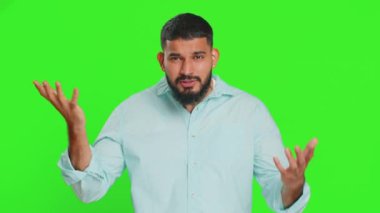 Sen delisin, aklın yerinde değil. Kafası karışmış Hintli bir adam kamerayı işaret edip aptalca bir jest yapıyor, aptal bir planı sorup kabadayılık taslıyor. Yeşil krom anahtar arka planında izole edilmiş bir Arap.