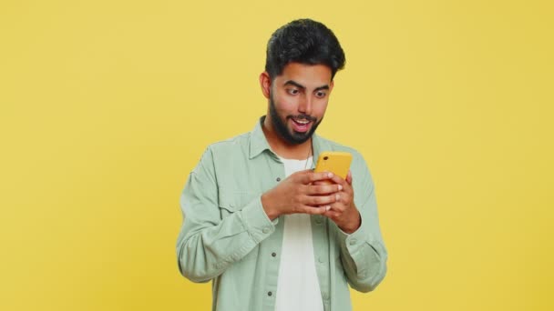 Szczęśliwy Podekscytowany Indyjski Młody Człowiek Facet Używać Smartfona Wpisując Przeszukiwanie — Wideo stockowe