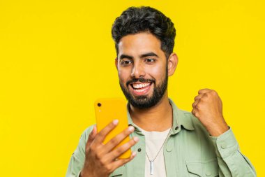 Mutlu Hintli genç adam akıllı telefon daktilo kullanıyor ve bağırıyor 