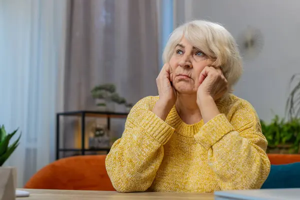 悲しみの肖像画 ストレスを受けた高齢の祖母の女性が自宅に座って 人生の懸念が不公平な状況に苦しんでいると考えているように見えます うつ病 バーンアウト ロイヤリティフリーのストック画像