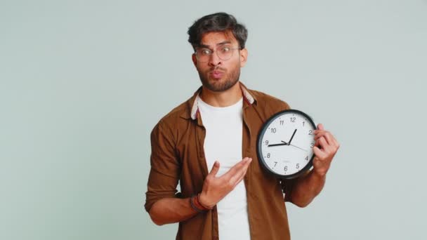 不安なインドの若者は 時計をチェックし 遅くまで仕事をし 遅刻期限を設けている スタジオグレーの背景に時間的隔離されることを心配するアラビアの男 — ストック動画