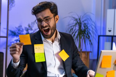 Ofiste dizüstü bilgisayar üzerinde çalışan yorgun Hintli işadamı üzerinde bir sürü etiket var. Serbest çalışan meşgul bir adam, aynı anda birden fazla iş yapmaktan sıkılıyor. Panik atak, son teslim tarihi