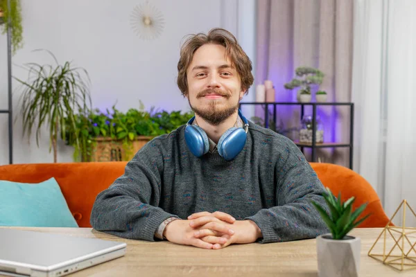 Portrait of happy calm bearded man at home table smiling friendly, glad expression looking away dreaming resting, relaxation feel satisfied good news, celebrate win. Caucasian young guy in office room
