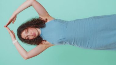 Başımı sokacak bir çatı. Çocuksu yakalama oyunu oynayan genç bir kadın başını sokacak bir çatı, sigorta ve güvenlik hizmetleri sağlama konusunda güvende hissediyor. Mavi stüdyo arka planında izole edilmiş bir kız. Dikey