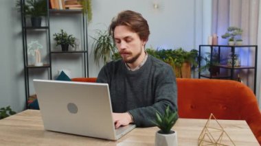 Sakallı adam ofis odasındaki işini bitirdikten sonra kanepeye oturup laptopunu kapatıyor. Genç Kafkasyalı serbest çalışan adam ev masasında uzaktan kumandayla çalışıyor. Defter bilgisayarında e-öğrenme, internette gezinme
