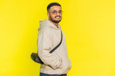 Neşeli, sevimli, mutlu, mutlu, Hintli bir adam gülümseyen, mutlu, mutlu bir yüz ifadesiyle kameraya bakan, dinlenme hayalleri kuran, rahatlatıcı, mutlu bir haber. Hindu sakallı adam sarı stüdyo arka planında izole edilmiş.