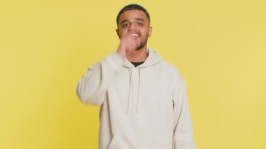 Seni seçiyorum. Hintli gülümseyen adam kamerayı işaret ediyor ve neşeli bir ifadeyle bakıyor, kazanan seçimi yapıyor, yön gösteriyor. Sarı stüdyo arka planında izole Arap genç adam