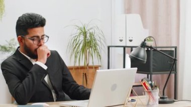 Sıkıcı, uykucu Hintli işadamı dizüstü bilgisayarda çalışıyor, esniyor, ofiste uyuya kalıyor. Yorgun, serbest çalışan, işkolik genç bir adam. İstihdam, meslek, işsiz