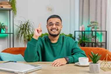 Evreka. Düşünceli, zeki, ilham verici Hintli adam parmağını kaldırır yaratıcı bir plan yapar. Evde ilham verici bir soru sorulunca heyecanlanır. Adam kanepede oturuyor.