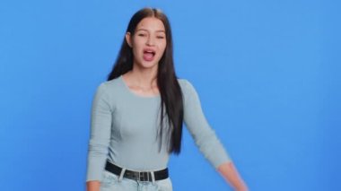 Ara beni, bu iletişim numarası. Beyaz bir kadın kameraya bakıyor telefon jesti yapıyor ve konuşmak istiyor. Çevrimiçi yardım hattı teklif reklamı. Mavi arkaplanda izole edilmiş kız