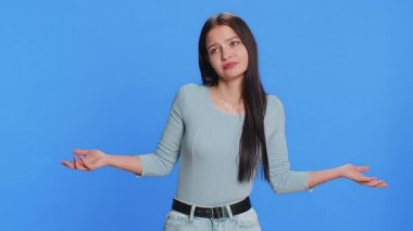 Ne diyecegimi bilmiyorum. Kafası karışmış Kafkasyalı genç bir kadın belirsiz bir sorudan utanıyor, şüpheleri var, cevap yok, fikir yok, bilgisiz, kararsız. Mavi arka planda izole edilmiş genç kız