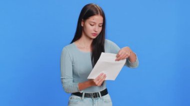 Zarfı açan genç bir kadın. Mektupta mutlu olduğu yazıyor. Kariyer gelişimi promosyonu, banka kredisi onayı, uzun zamandır beklenen para ödülü davetiyesi harika haberler. Güzel esmer, mavi elbiseli yetişkin kız.